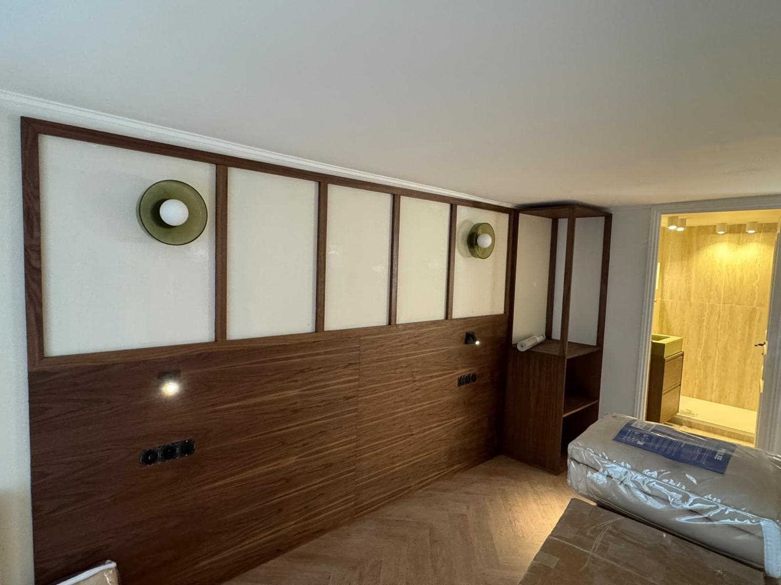 Chambre avec tête de lit en noyer, panneaux encadrés et appliques murales