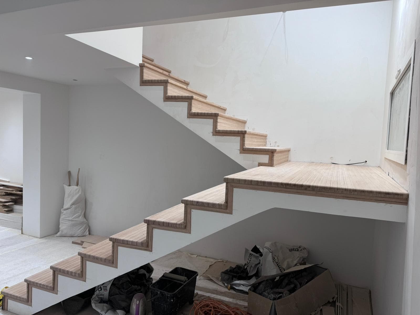 Escalier habillé de marches en bois dans un volume blanc