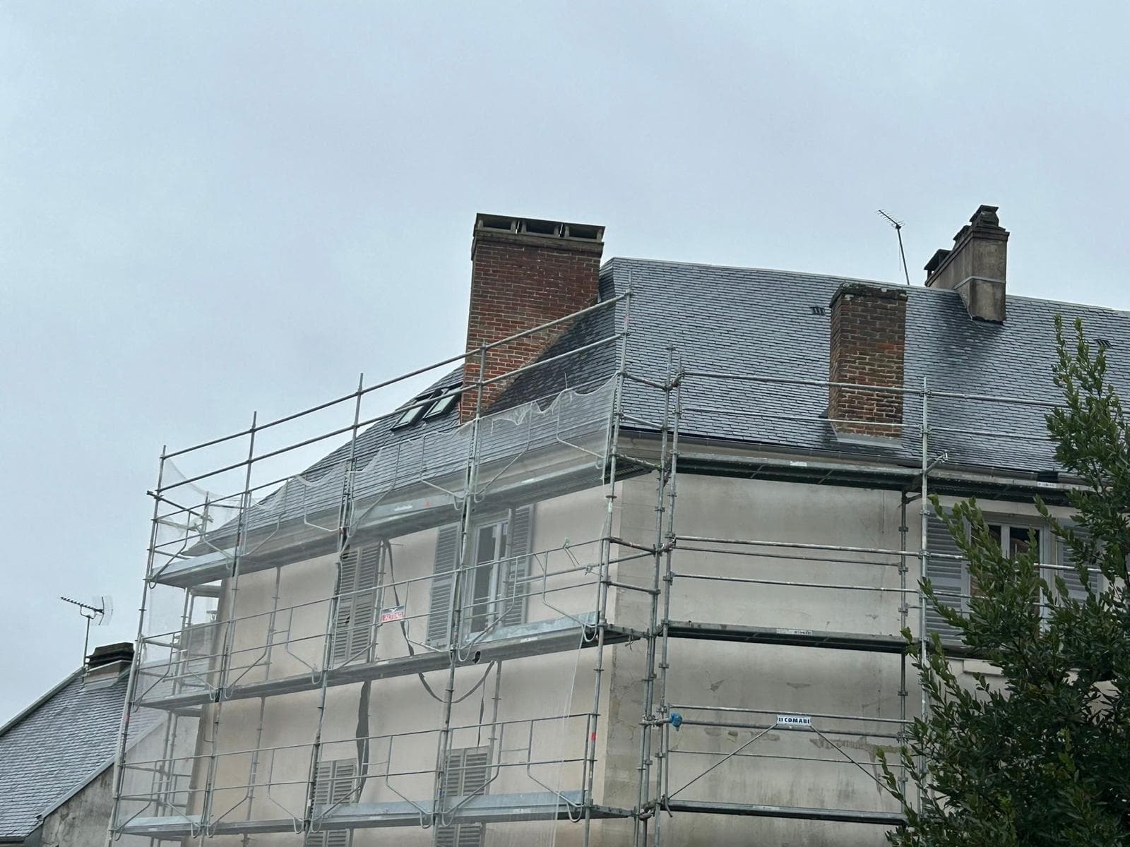 Maison bourgeoise à toiture en ardoise sous échafaudage de ravalement
